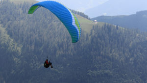 Das Bild zeigt den Gleitschirm Gin Gliders Atlas 2 mit Sitzgurtezeug im Flug in Werfenweng.