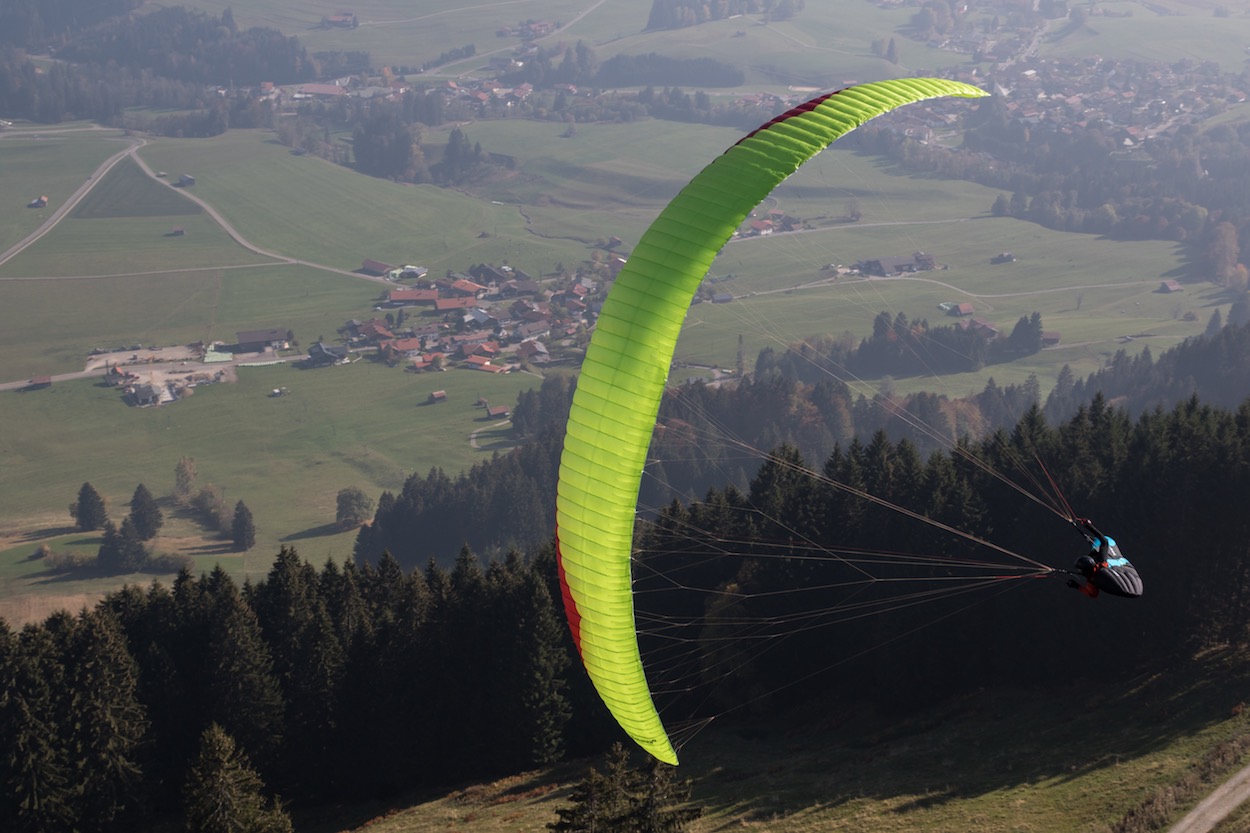 Das Bild zeigt den neuen Bonanza 2 von Gin Gliders. Es ist ein Gleitschirm der Kategorie C. Auf dem Bild befindet sich der Gleitschirm in einer Kurve während eines Testflug bei der oASE Flugschule im Allgäu.